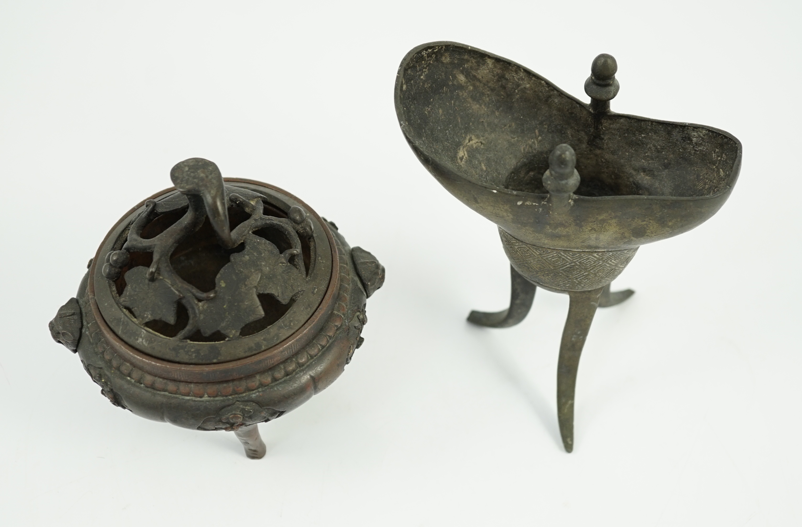 A Chinese bronze and copper alloy tripod censer and cover and a Chinese archaistic bronze tripod vessel, yi, both 17th century